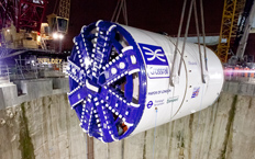 Vista frontal de la tuneladora empleada para la creación del tunel mientras la están bajando al mismo